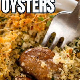 A fork is digging into a serving of cheesy baked oysters.