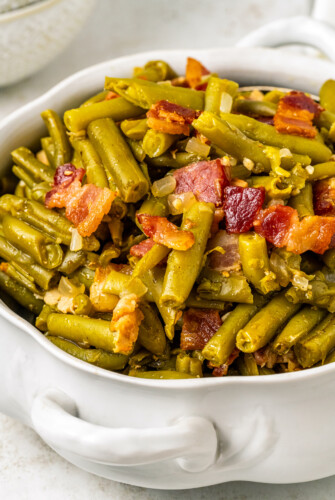 A white serving bowl of homemade crock pot green beans.