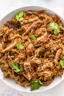 Juicy and tender shredded crock pot carnitas placed in a serving bowl.